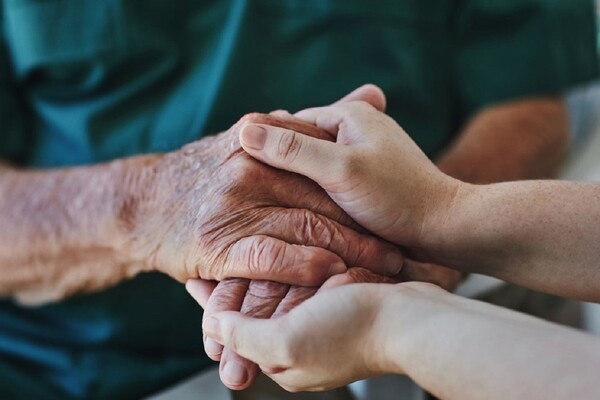 younger hands grasping older hands